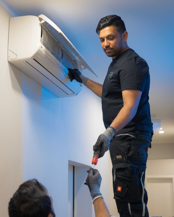 Facility Service Mitarbeiter bei der Wartung einer Klimaanlage für Unternehmen in Essen